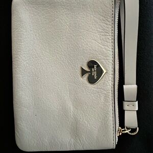 kate spade light gray leather wristlet with gold spade emblem